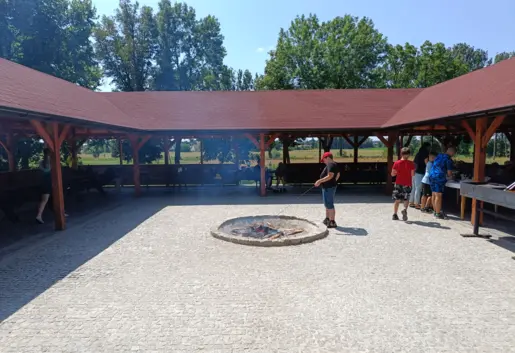 Wiata grillowa - wnętrze wykonana z kostki. Dookoła teren zielony. Miejsca siedzące jestesmy w stanie dopasować do grupy.