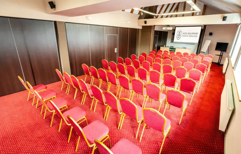 Wyposażona w klimatyzację, nowoczesny projektor, nagłośnienie, zapewniaj dostęp do światła dziennego, jak również całkowite zaciemnienie poprzez elektrycznie sterowane rolety okienne.